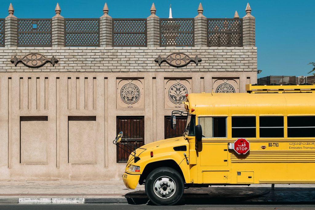 yellow school bus on route against historic building