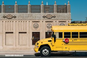 yellow school bus on route against historic building